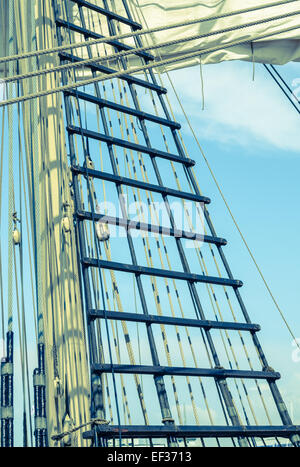 Sails and tackles of a sailing vessel on a background of the sky. Cross process Stock Photo