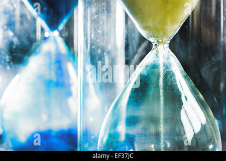 timer hourglass streaming grains of sand flowing through depicting things are running out Stock Photo