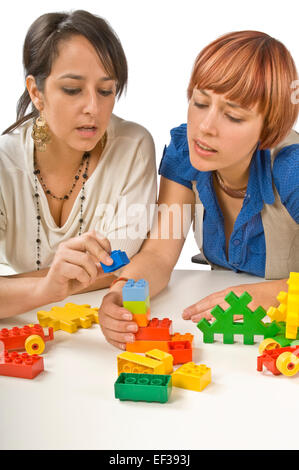 Two women playing with building blocks Stock Photo