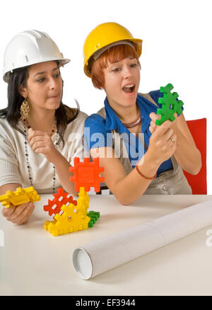 Two women playing with child's building toy Stock Photo