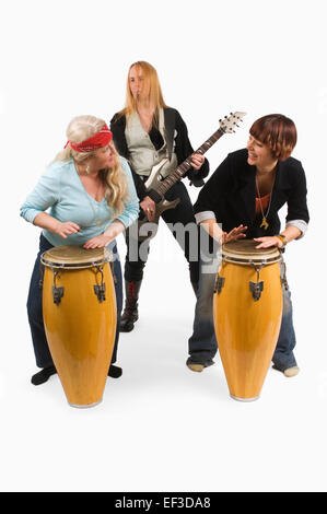 Two women playing drums with guitarist behind them Stock Photo