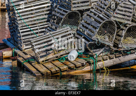Old wooden lobster traps with buoys and rope on a wharf in Newfoundland, Canada. Stock Photo