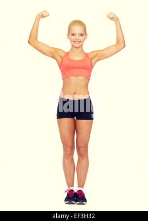 smiling sporty woman flexing her biceps Stock Photo