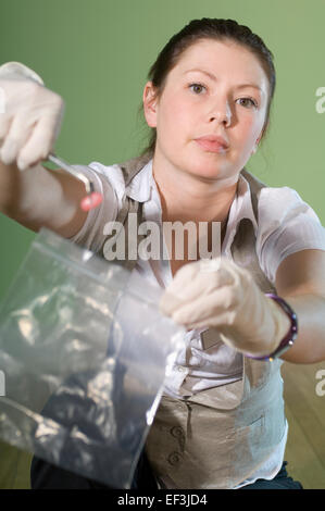 Detective bagging evidence at crime scene Stock Photo