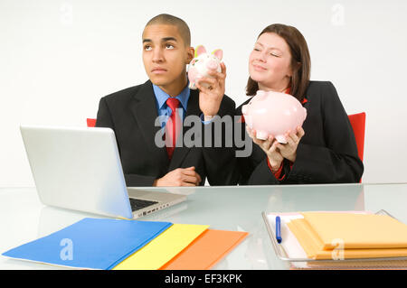 Colleagues holding piggy banks Stock Photo