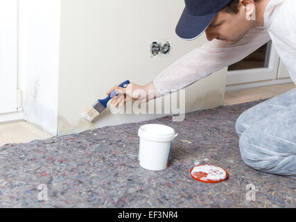 Painter paints damp walls in an apartment with a special color Stock Photo