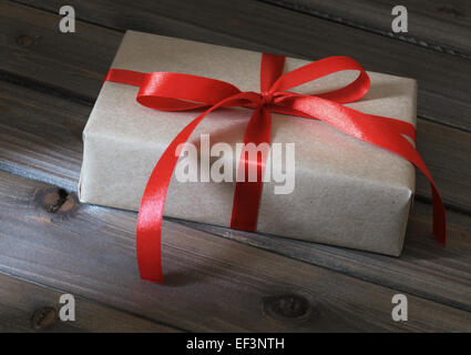 Vintage gift box wrapped in kraft paper on wooden background Stock Photo