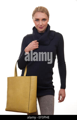 blonde woman going shopping carrying a yellow tote bag Stock Photo