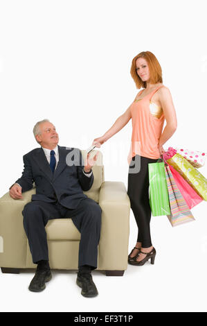 Woman handing her credit card to man Stock Photo