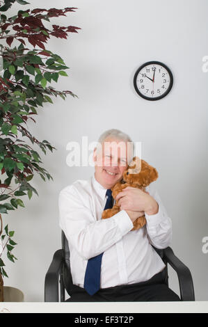 Businessman hugging a teddy bear Stock Photo