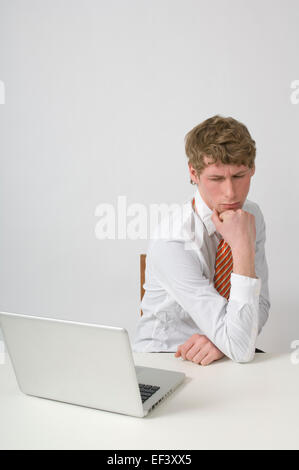 Man deep in thought at his desk Stock Photo