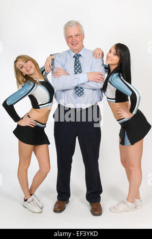 Cheerleaders standing with teacher Stock Photo