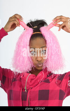 Girl holding cheerleader pom poms in front of her face Stock Photo