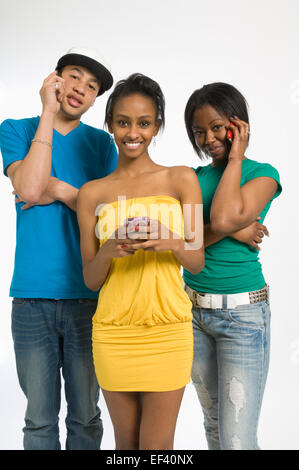 Three teenagers holding cell phones Stock Photo