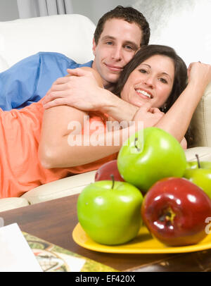 Couple relaxing on couch together Stock Photo