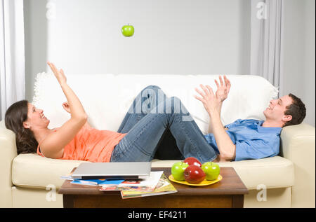 Couple playing toss with an apple Stock Photo