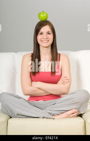 Woman balancing an apple on her head Stock Photo