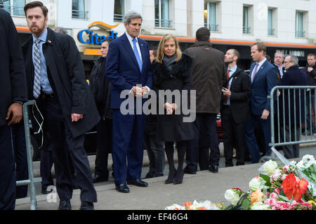 U.S. Secretary of State John Kerry and U.S. Ambassador to France Jane Hartley look at the impromptu floral memorial that arose on the sidewalk where French Police Officer Ahmed Merabet was shot and killed as they stopped throughout Paris, France, on January 16, 2015, to pay homage to those killed during last week's shootings in the capital. Stock Photo