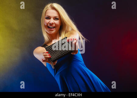 Fashion elegant outfit. Stylish woman fashionable blonde girl with black rivet leather handbag bag in night club dancing. Stock Photo