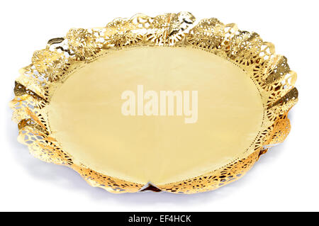 a golden paper lace doily on a cake board for display cakes on a white background Stock Photo