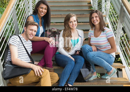 Smiling students sitting on steps Stock Photo