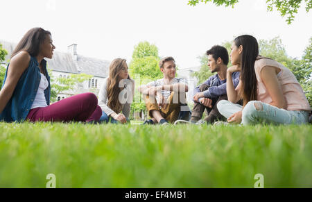 Happy students sitting outside on campus Stock Photo