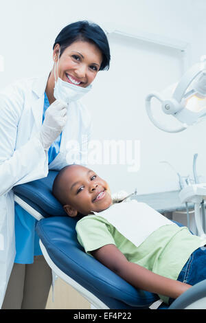 Portrait of smiling female dentist examining boys teeth Stock Photo