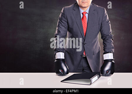 portrait of a male office worker with boxing gloves in the defensive stance Stock Photo