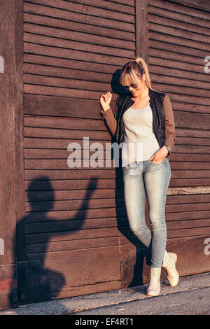 Young woman looking at silhouette of young man on wooden wall Stock Photo