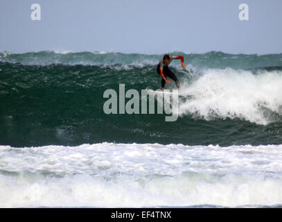 Surfer riding large waves off Porthmeor beach, St Ives, Cornwall Stock Photo