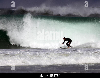 Surfer riding large waves off Porthmeor beach, St Ives, Cornwall Stock Photo