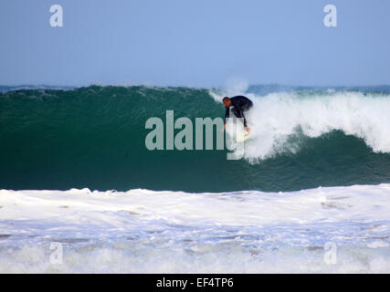 Surfer riding large waves off Porthmeor beach, St Ives, Cornwall Stock Photo