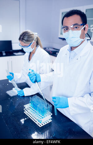 Science students using pipettes to fill test tubes Stock Photo