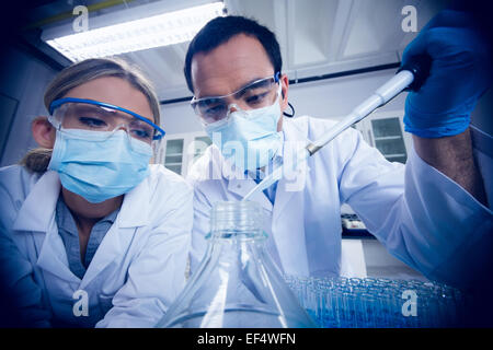 Science students using pipette to fill beaker Stock Photo