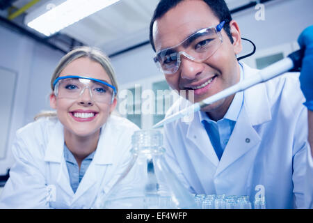 Science students using pipette to fill beaker Stock Photo