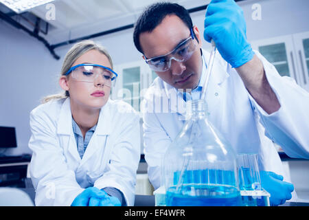 Science students using pipette to fill beaker Stock Photo