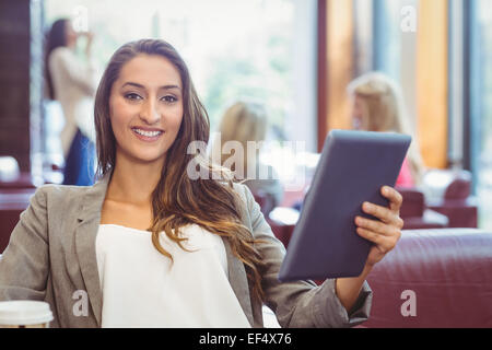 Student using digital tablet and holding disposable cup Stock Photo