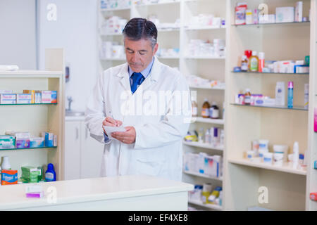 Focused pharmacist writing down notes Stock Photo