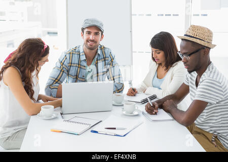 Colleagues taking notes and using laptop Stock Photo