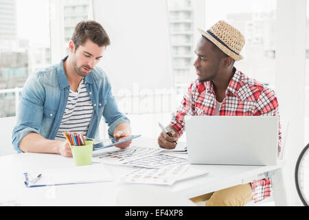 Colleagues sitting using tablet and laptop Stock Photo