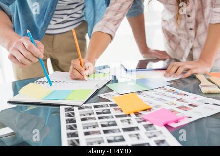 Colleagues writing notes and editing photos Stock Photo