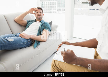 Man lying on sofa talking to his therapist Stock Photo
