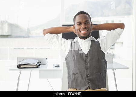 Relaxed businessman with hands behind head Stock Photo