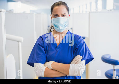 Dentist wearing surgical mask with arms folded Stock Photo