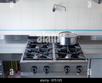 large pot over the stove's gas stainless steel industrial kitchen Stock Photo