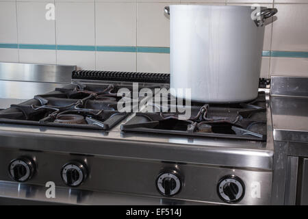 large aluminum pot over the stove's gas stainless steel industrial kitchen Stock Photo