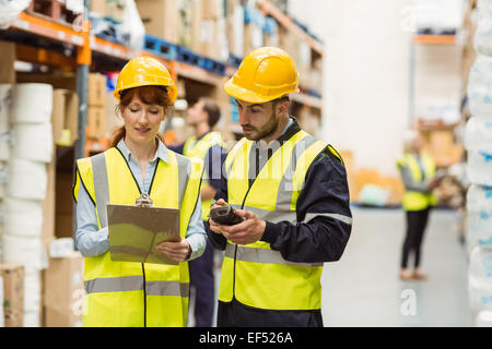 Warehouse manager talking with worker Stock Photo