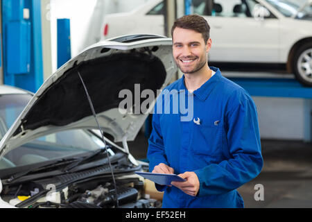 Smiling mechanic using a tablet pc Stock Photo