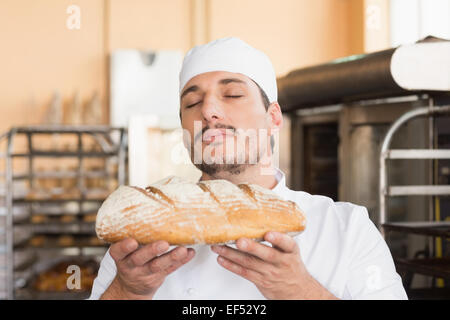 Baker smelling freshly baked loaf Stock Photo