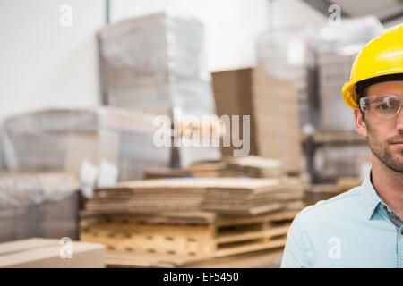 Close up of worker wearing hard hat in warehouse Stock Photo